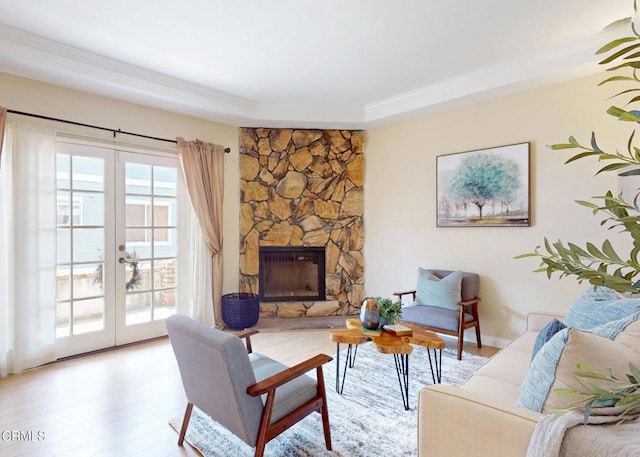 living room featuring a fireplace, french doors, and light wood-style floors