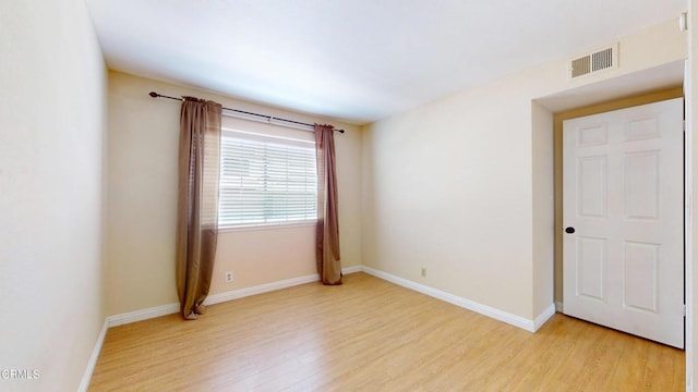 spare room with visible vents, baseboards, and light wood-type flooring