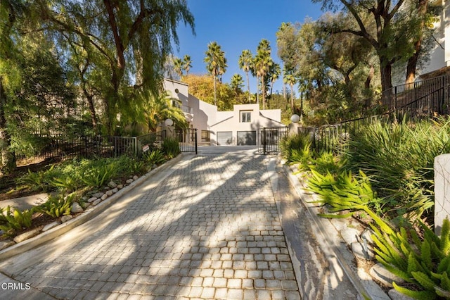 exterior space with fence private yard, a gate, and decorative driveway