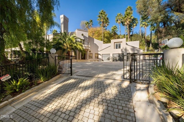 exterior space with a garage, a gate, stucco siding, and fence