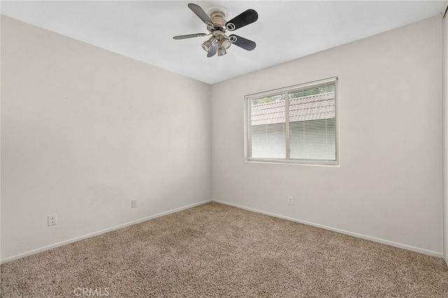 spare room featuring baseboards, ceiling fan, and light carpet