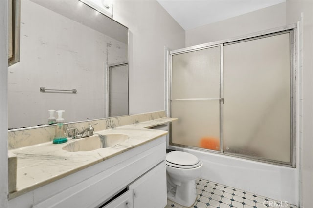 bathroom featuring vanity, bath / shower combo with glass door, tile patterned floors, and toilet