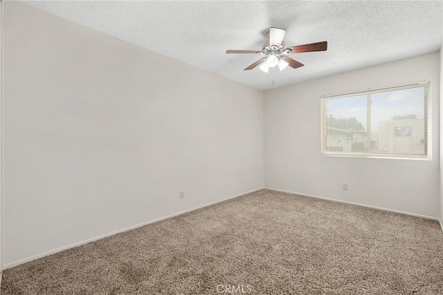 carpeted spare room featuring a ceiling fan, a textured ceiling, and baseboards