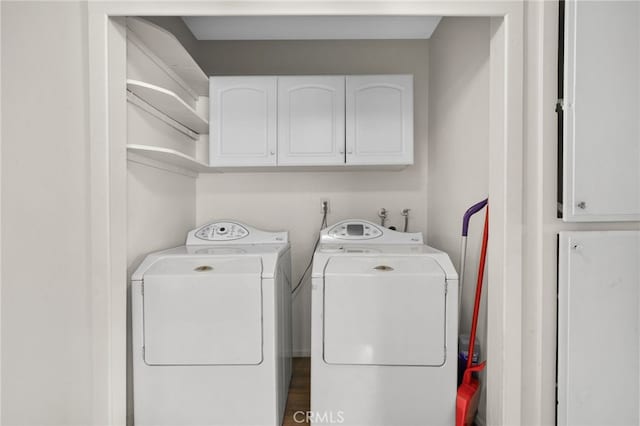 clothes washing area featuring cabinet space and washer and dryer