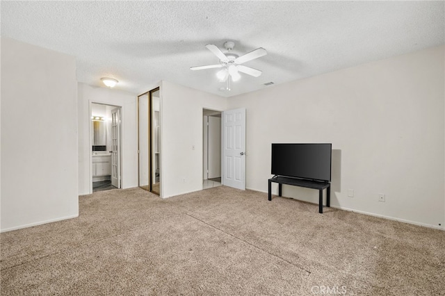 unfurnished living room featuring carpet flooring, a ceiling fan, a textured ceiling, and baseboards