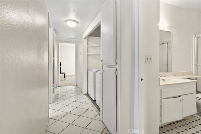 corridor with washer and dryer and light tile patterned floors