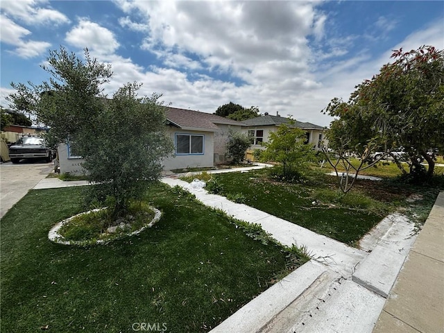 view of front of property featuring a front lawn and stucco siding