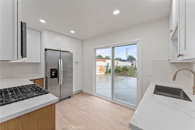 920 W Hollyvale St, Azusa, CA 91702 - kitchen featuring stainless steel refrigerator with ice dispenser, a sink, light wood-type flooring, tasteful backsplash, and white cabinetry