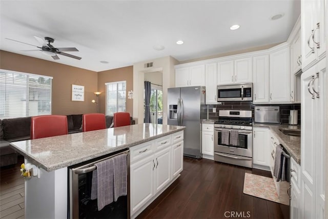 4 Mosaic, Aliso Viejo, CA 92656 - kitchen featuring visible vents, beverage cooler, open floor plan, a center island, and appliances with stainless steel finishes