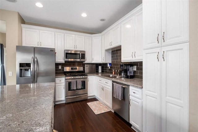 4 Mosaic, Aliso Viejo, CA 92656 - kitchen with dark wood-type flooring, appliances with stainless steel finishes, light stone counters, and white cabinets