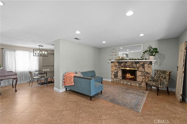 living area with an inviting chandelier, a fireplace, baseboards, light tile patterned floors, and visible vents