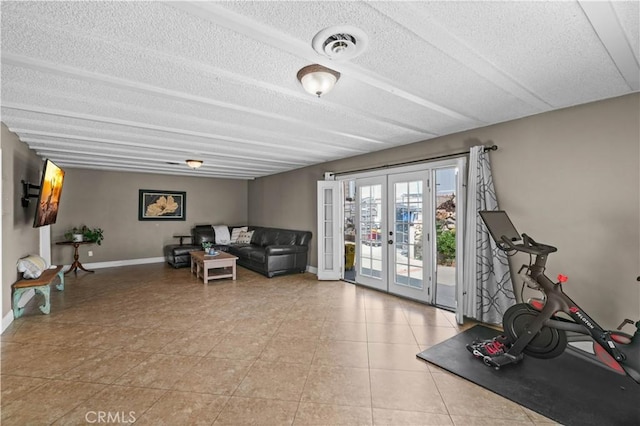 exercise area featuring baseboards, a textured ceiling, visible vents, and french doors