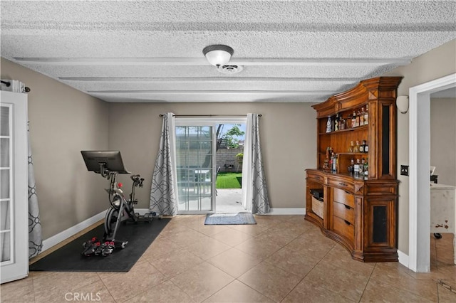 entryway featuring light tile patterned floors, baseboards, and a textured ceiling