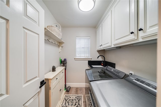 26122 Augusta Dr, Lake Arrowhead, CA 92352 - washroom with washing machine and dryer, baseboards, cabinet space, a sink, and light wood-style flooring