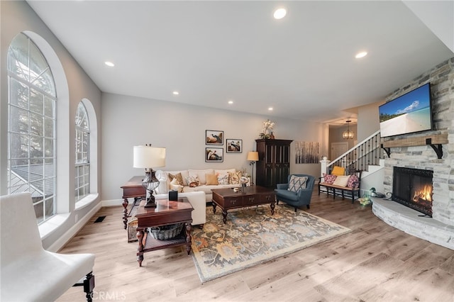 26122 Augusta Dr, Lake Arrowhead, CA 92352 - living room with wood finished floors, recessed lighting, a stone fireplace, baseboards, and stairs