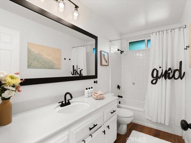 bathroom with vanity, wood finished floors, shower / bath combination with curtain, and toilet