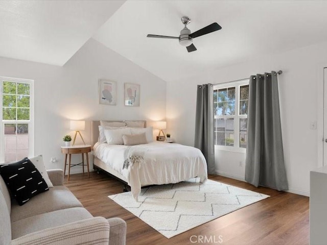 bedroom with a ceiling fan, baseboards, vaulted ceiling, and wood finished floors