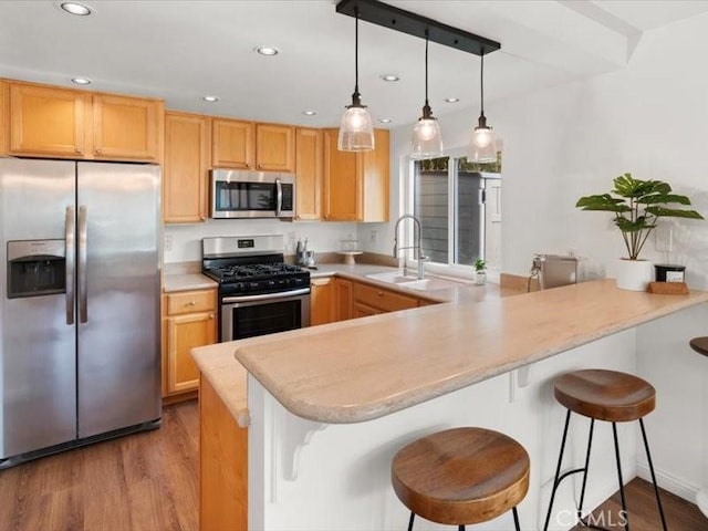 kitchen featuring a peninsula, light wood-type flooring, recessed lighting, light countertops, and appliances with stainless steel finishes