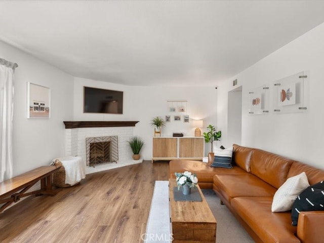 living room featuring a fireplace, wood finished floors, and visible vents
