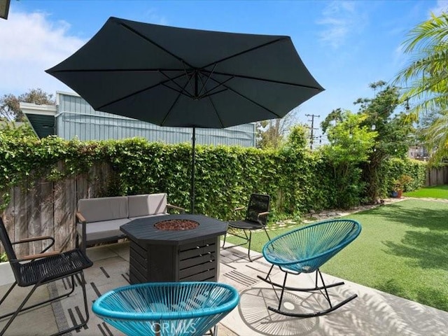 view of patio featuring a fenced backyard and an outdoor fire pit
