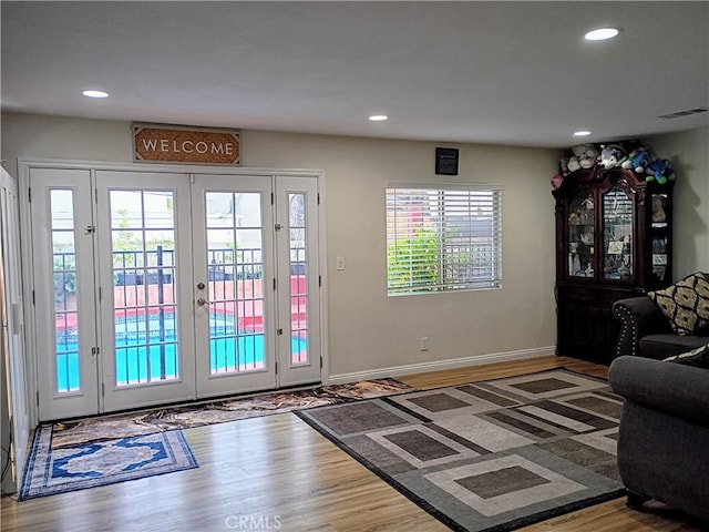 doorway to outside with recessed lighting, french doors, and wood finished floors