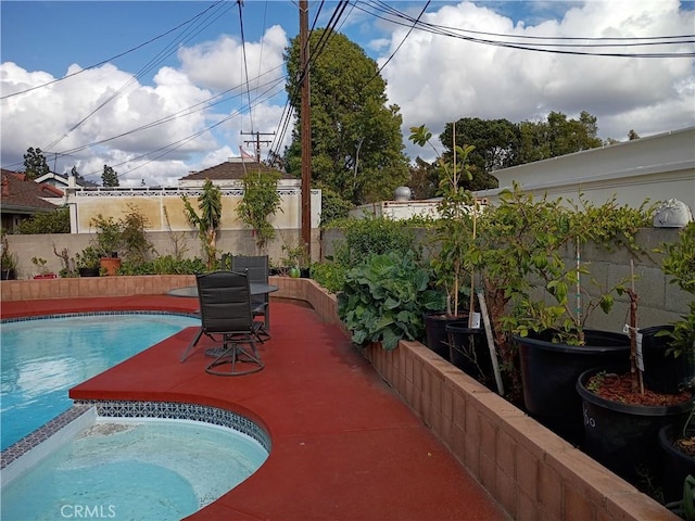 view of swimming pool with a fenced backyard and a pool with connected hot tub