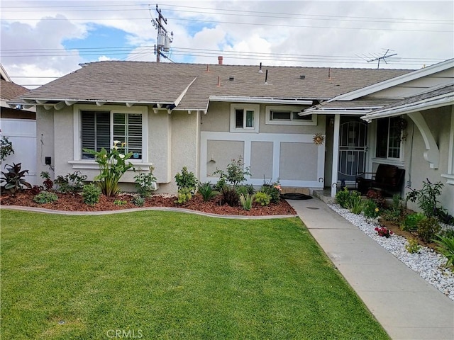 view of front of home with roof with shingles, stucco siding, and a front lawn
