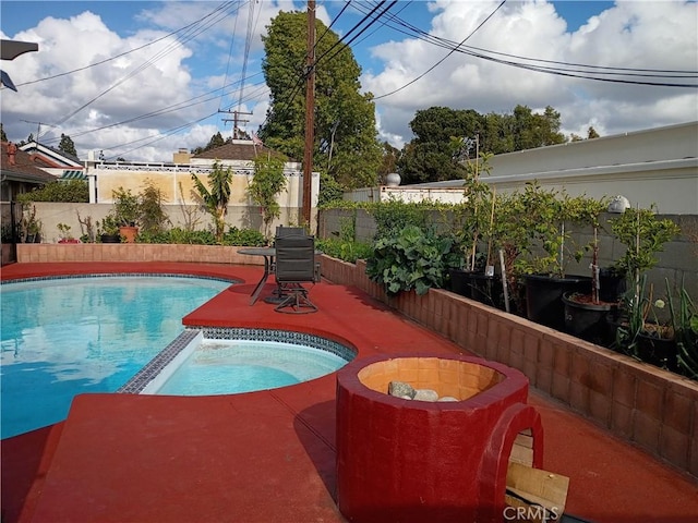 view of swimming pool with a fenced backyard, a patio area, and a pool with connected hot tub