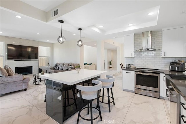 kitchen with wall chimney range hood, visible vents, recessed lighting, stainless steel electric stove, and modern cabinets