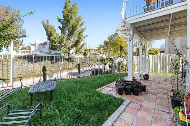 view of yard featuring a fenced backyard, a patio area, and a balcony