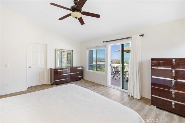 bedroom with ceiling fan, vaulted ceiling, wood finished floors, baseboards, and access to outside