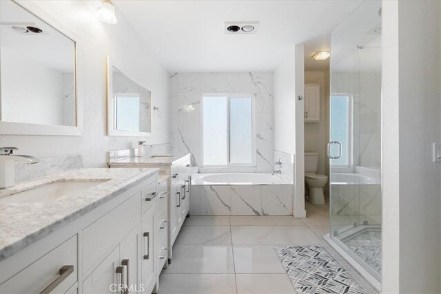 full bathroom with double vanity, toilet, a bath, a sink, and a marble finish shower