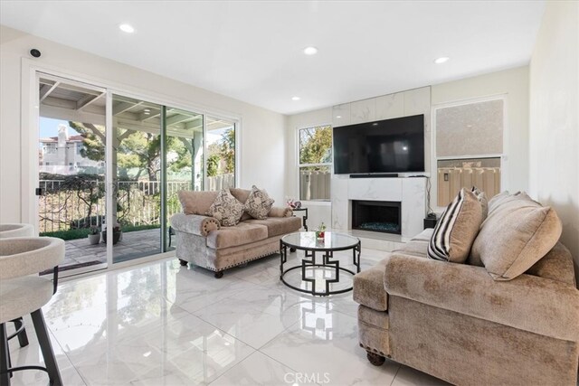 living area featuring recessed lighting, a premium fireplace, and marble finish floor