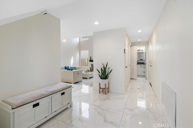 hall featuring recessed lighting, visible vents, and marble finish floor
