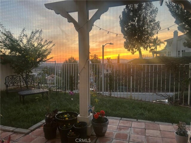 patio terrace at dusk with a fenced backyard