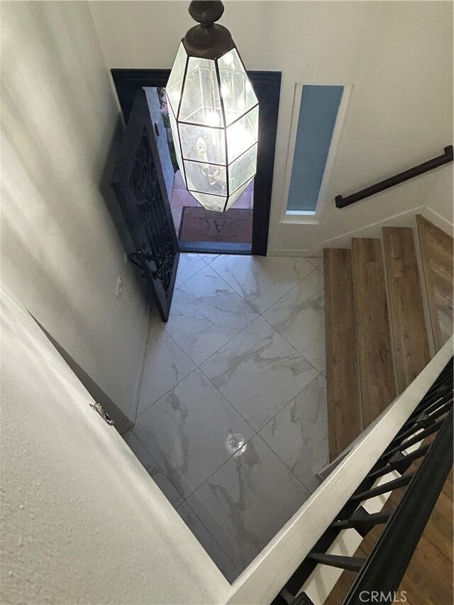 entryway with stairs and marble finish floor