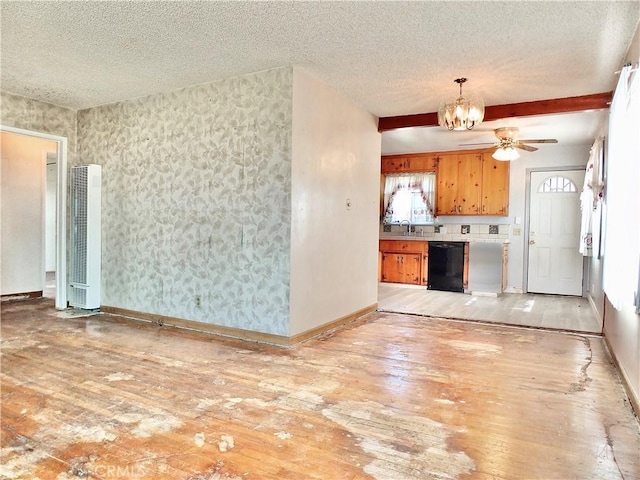 unfurnished living room featuring a textured ceiling, a heating unit, ceiling fan with notable chandelier, baseboards, and light wood-type flooring