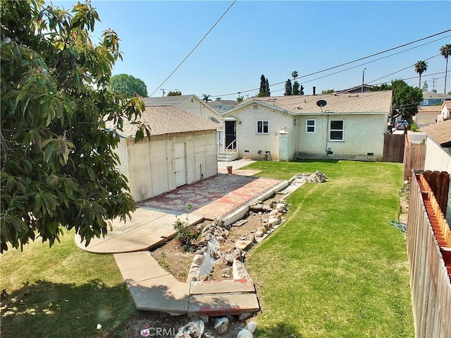 back of property featuring a fenced backyard, a storage unit, an outbuilding, a patio area, and a yard