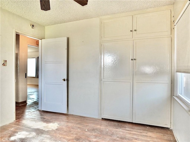 unfurnished bedroom with a ceiling fan, a textured ceiling, and a closet