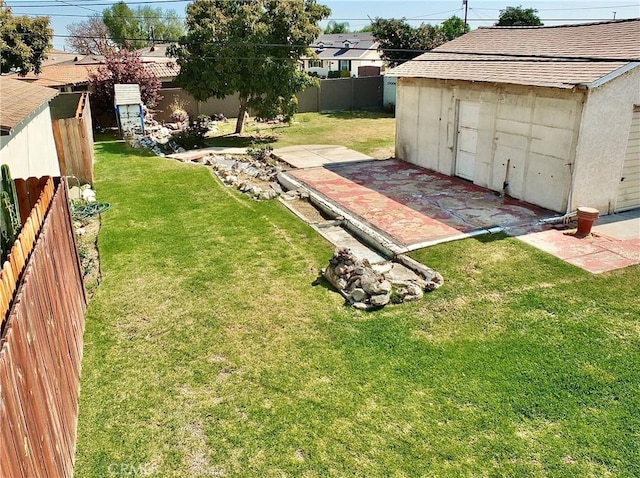 view of yard with an outbuilding, a fenced backyard, a patio area, and a shed