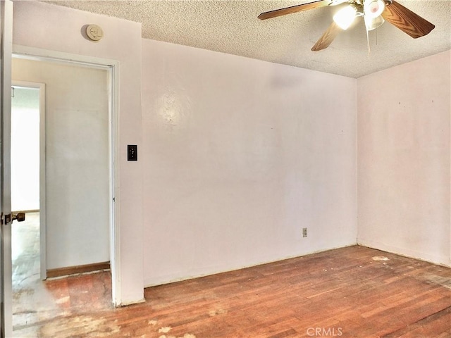 empty room with a textured ceiling, a ceiling fan, and wood finished floors