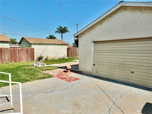 view of patio / terrace featuring fence and a garage