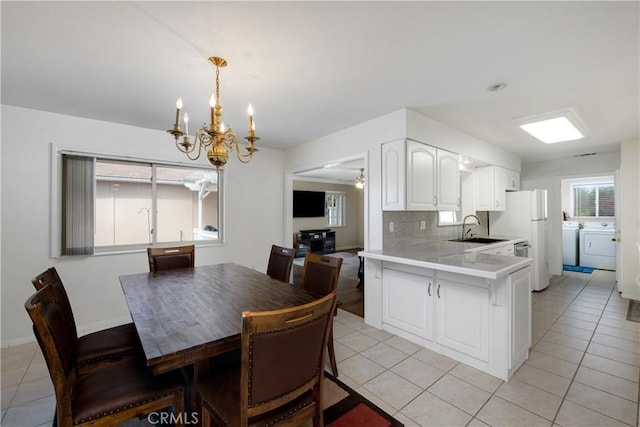28970 Exmoor Ct, Menifee, CA 92586 - dining area featuring washer and dryer, a chandelier, and light tile patterned flooring