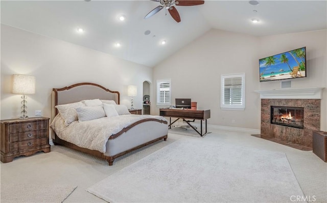 bedroom featuring arched walkways, high vaulted ceiling, carpet, baseboards, and a high end fireplace