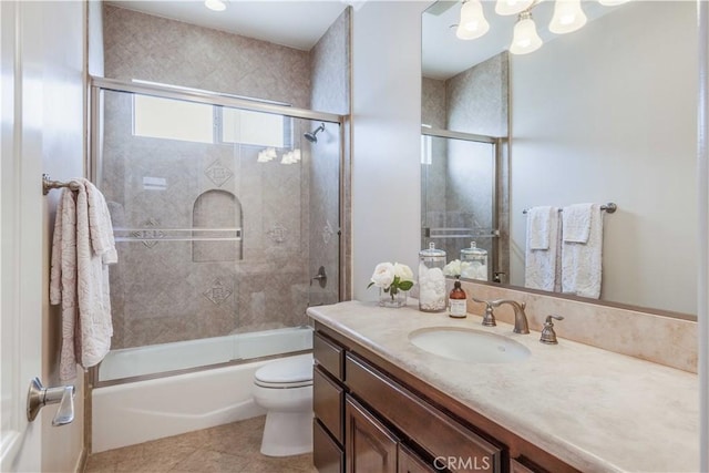 full bath featuring vanity, tile patterned flooring, bath / shower combo with glass door, and toilet