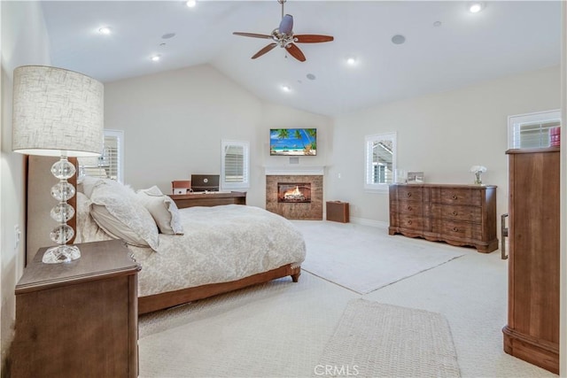 carpeted bedroom featuring a glass covered fireplace, ceiling fan, vaulted ceiling, and recessed lighting