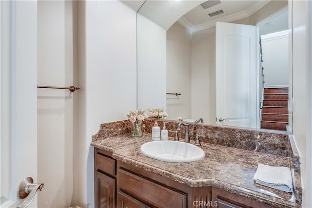 bathroom featuring visible vents, ornamental molding, and vanity