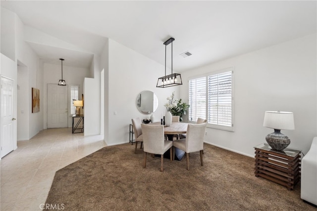 dining room featuring baseboards, visible vents, and vaulted ceiling