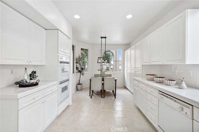 kitchen featuring white appliances, white cabinetry, recessed lighting, and backsplash