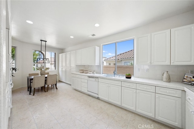 kitchen with white dishwasher, white cabinets, and recessed lighting